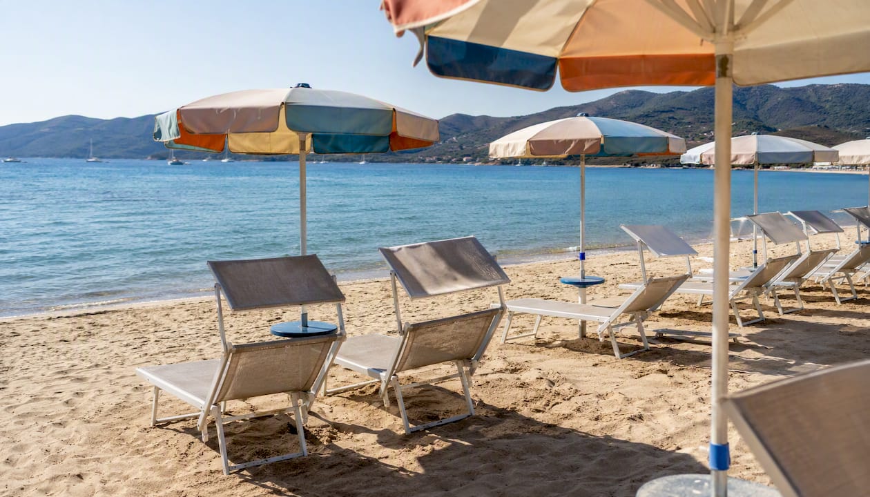 Lettini e ombrelloni a disposizione degli ospiti dell’Hotel Delfino per godersi il sole e il relax sulla spiaggia.