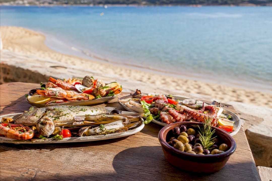 Piatto di frutti di mare freschi su tavolo in spiaggia toscana